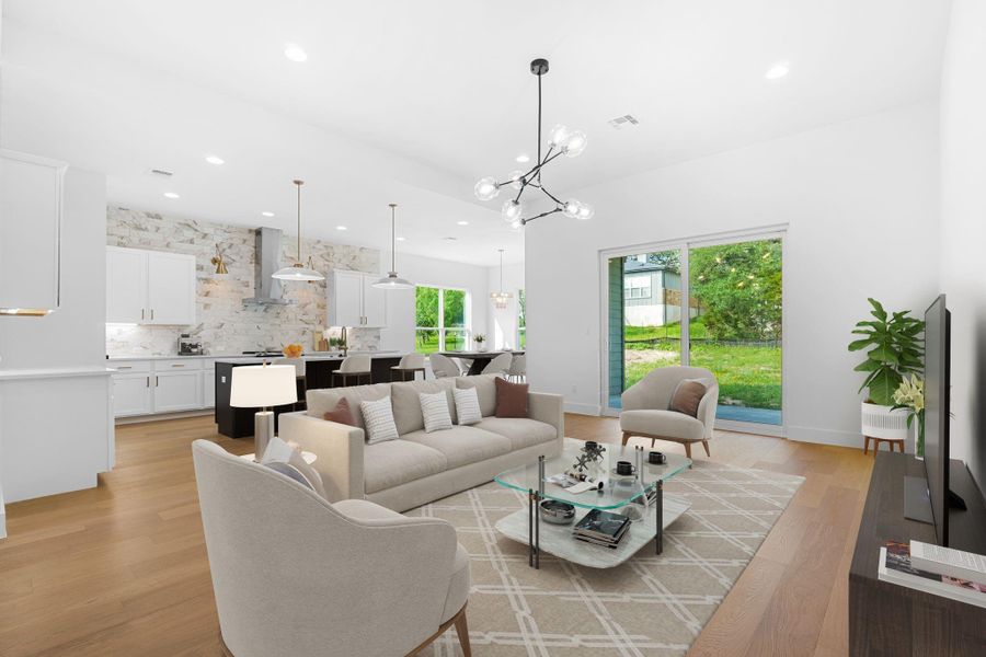 Living room with a chandelier and light hardwood / wood-style floors Living room with a chandelier and light hardwood / wood-style floors
