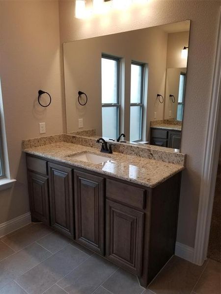 Master bath features separate granite vanities, garden tub, and separate shower with frameless glass