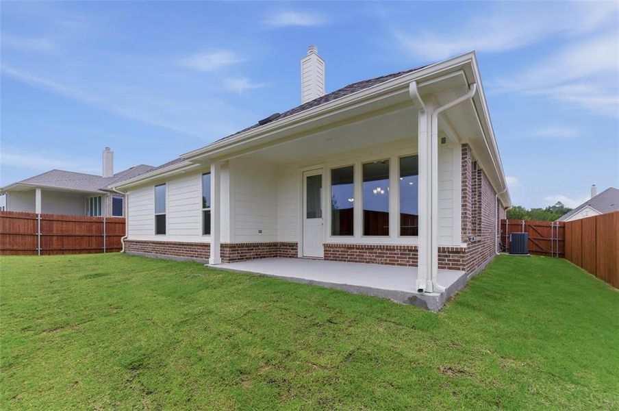 Covered patio with a concrete slab, brick base, and white siding
