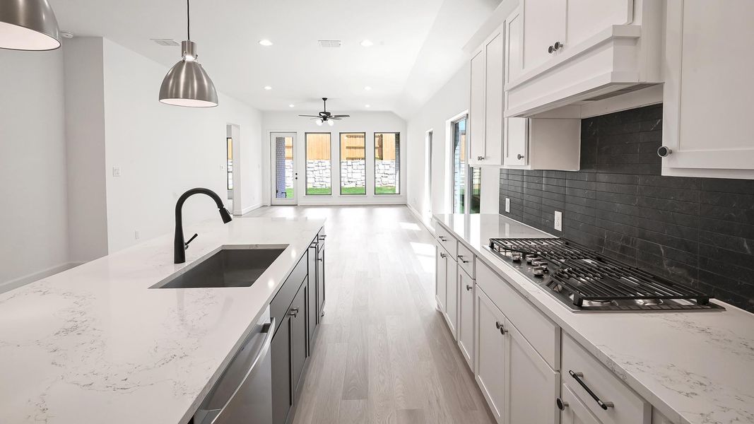 Kitchen with white cabinetry, light wood finished floors, appliances with stainless steel finishes, recessed lighting, and decorative light fixtures Kitchen with white cabinetry, light wood finished floors, appliances with stainless steel finishes, recessed lighting, and decorative light fixtures