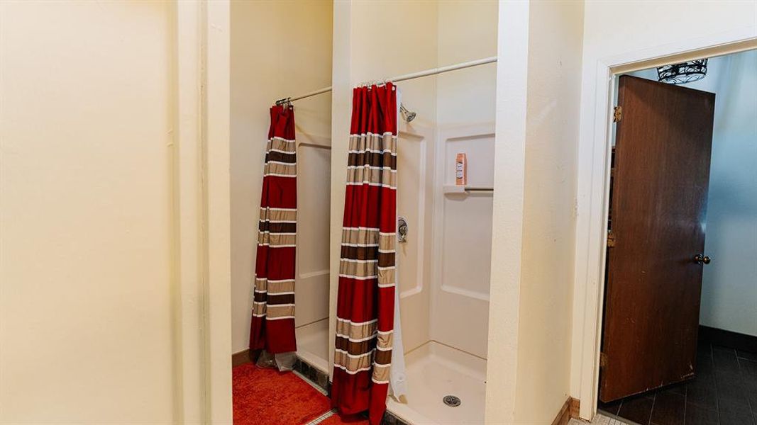 Bathroom with a stall shower and dark tile patterned floors