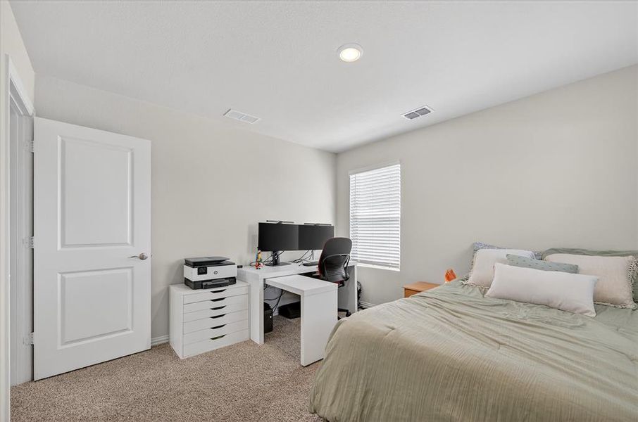 Bedroom with light colored carpet, a desk, and recessed lighting