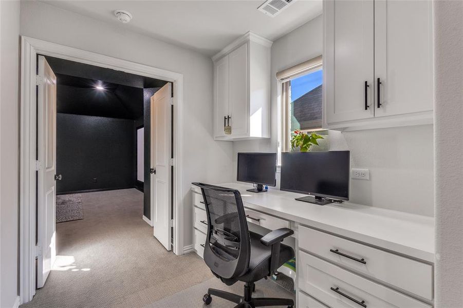Office area with light colored carpet and baseboards