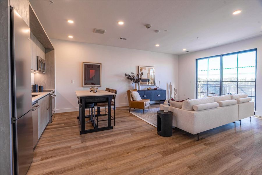 Living room featuring recessed lighting and light wood-type flooring.Photos shown are of a model residence and are representative in nature. Actual residence may differ in layout, finishes, and views.