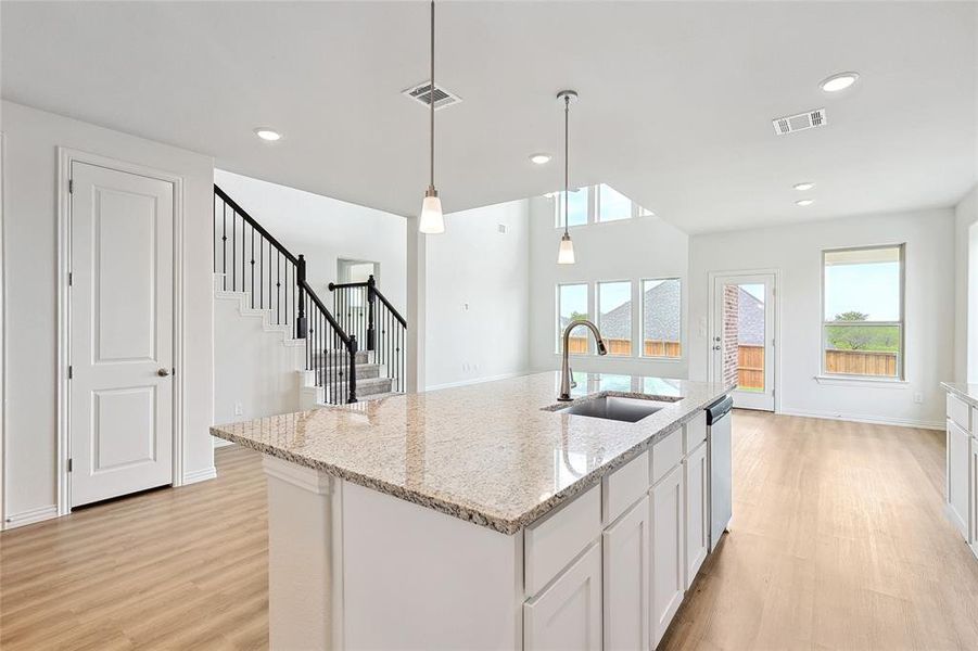 Kitchen featuring light hardwood / wood-style flooring, an island with sink, white cabinetry, and sink