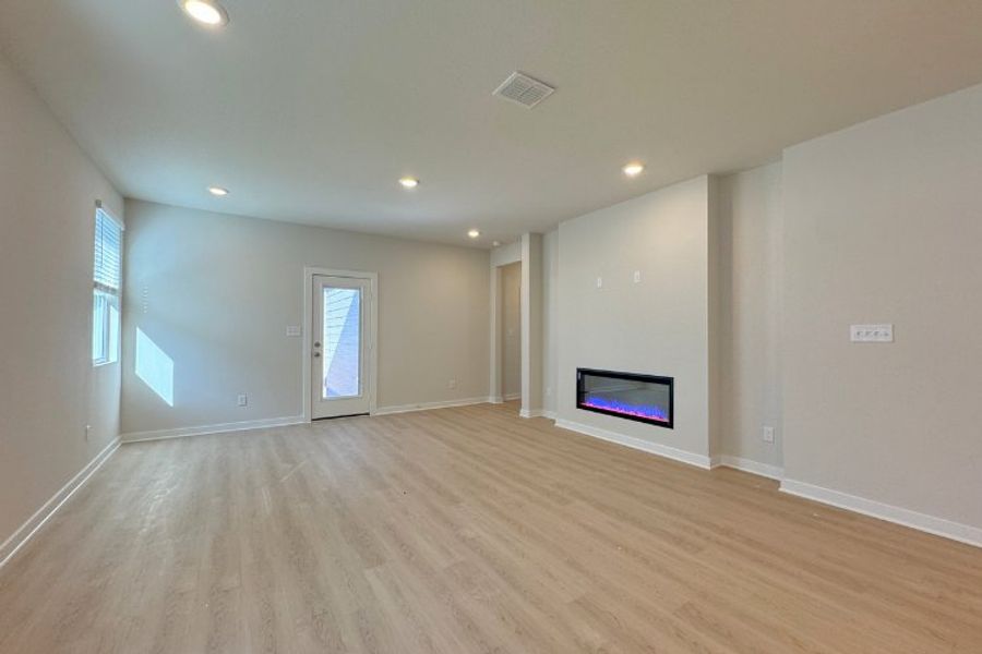 A room with a tv and a wood floor.