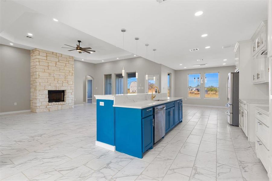 Kitchen with white cabinetry, arched walkways, pendant lighting, open floor plan, and light marble finish flooring