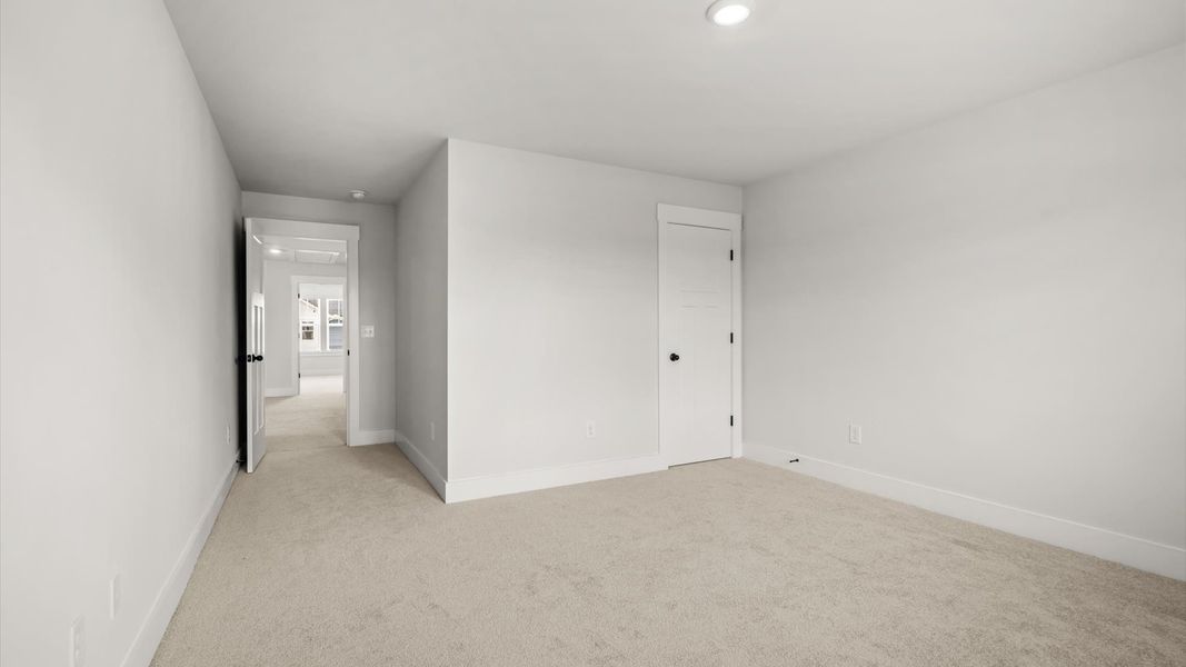 Highly functional bedroom with walk-in closet and tasteful carpet for a restful retreat