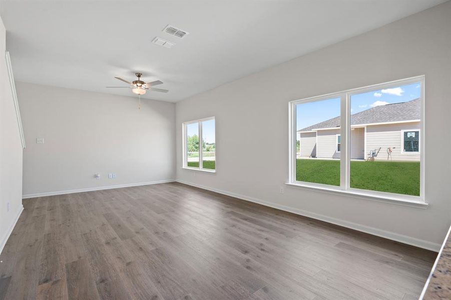 Empty room with light wood-style floors and ceiling fan