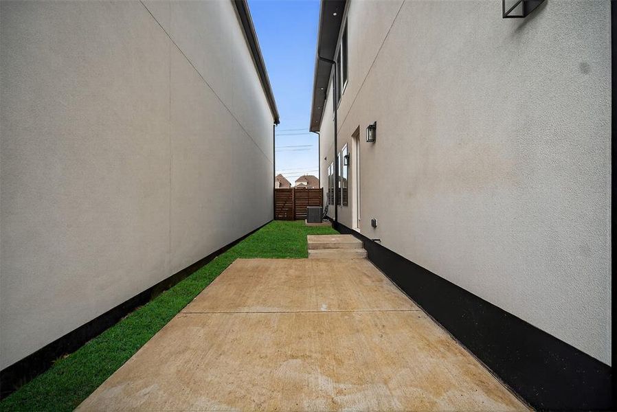 View of side of home with stucco siding and a patio