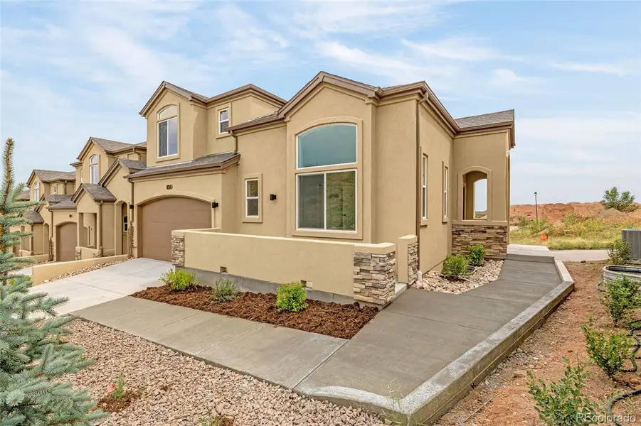 Front exterior of a new home in , Colorado Springs, CO, highlighting curb appeal (Image 1).