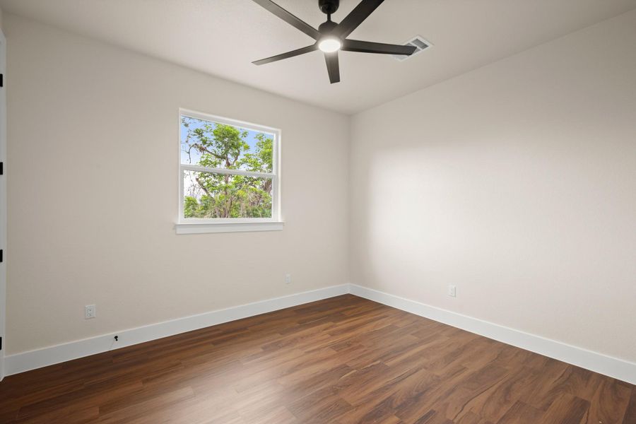 Spare room featuring a ceiling fan and dark wood-type flooring