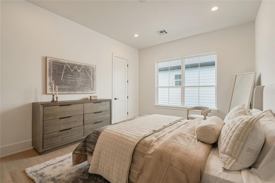 This secondary bedroom feels bright and inviting, with well-proportioned dimensions and a large window creating a comfortable retreat for family or overnight guests.