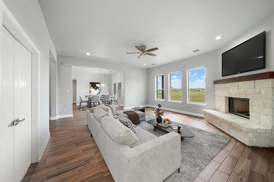 Living room with a fireplace, hardwood / wood-style flooring, and ceiling fan