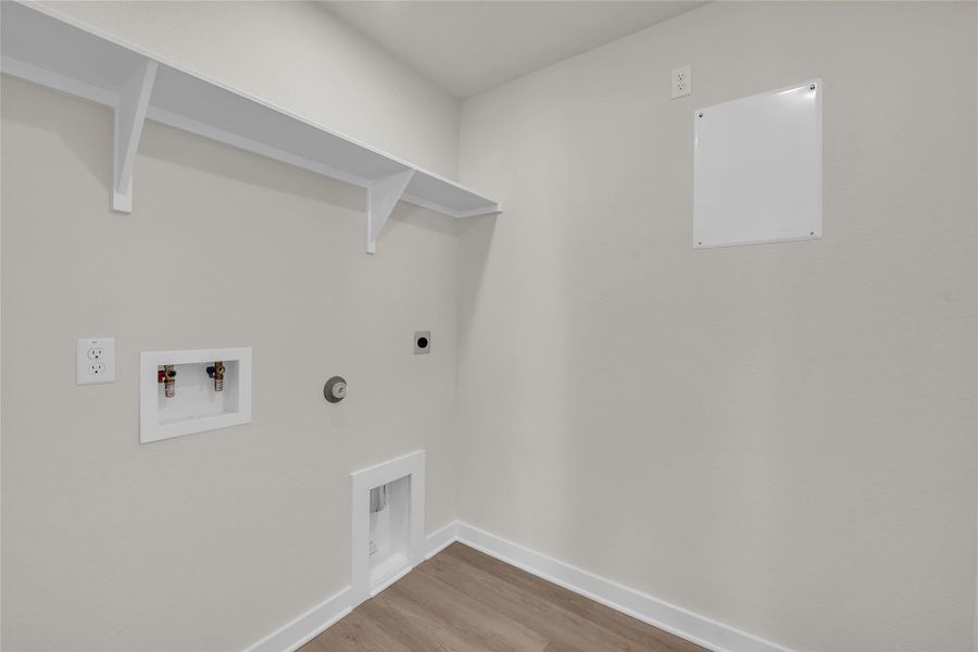 Laundry room with wood finished floors, baseboards, gas dryer hookup, laundry area, and electric dryer hookup