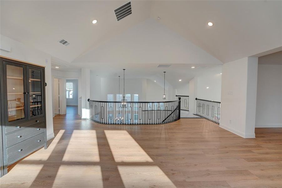 Corridor with high vaulted ceiling, baseboards, visible vents, and vinyl finished floors