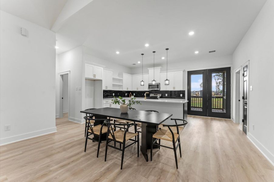 Spacious dining area filled with natural light from large windows. Spacious dining area filled with natural light from large windows.
