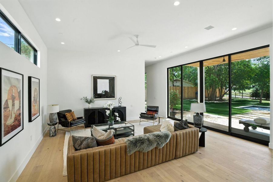 Living area with healthy amount of natural light, recessed lighting, light wood-style flooring, and ceiling fan Living area with healthy amount of natural light, recessed lighting, light wood-style flooring, and ceiling fan