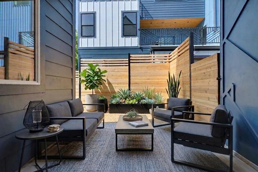 COVERED rear patio with custom accent wall and cedar privacy fencing. **Virtually Staged Furniture and Accessories** COVERED rear patio with custom accent wall and cedar privacy fencing. **Virtually Staged Furniture and Accessories**