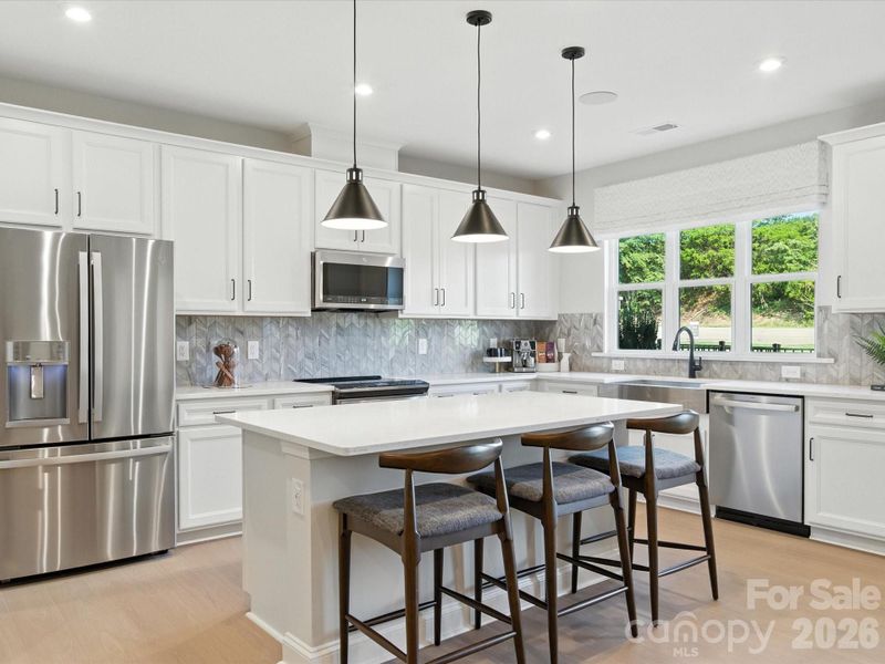 Chef-inspired kitchen with white cabinets and white quartz countertops