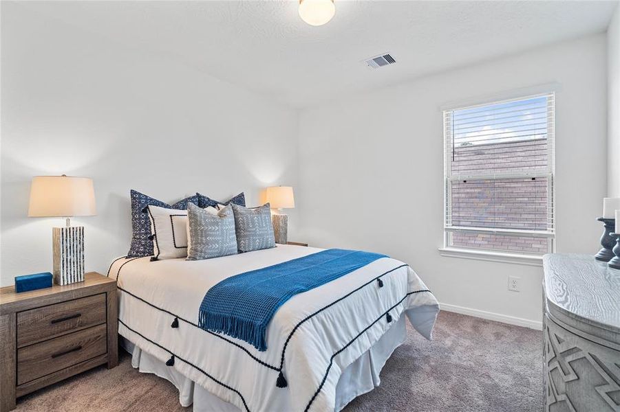 Secondary bedroom features plush carpet, neutral paint, lighting, large windows with privacy blinds and ample sized closet space.