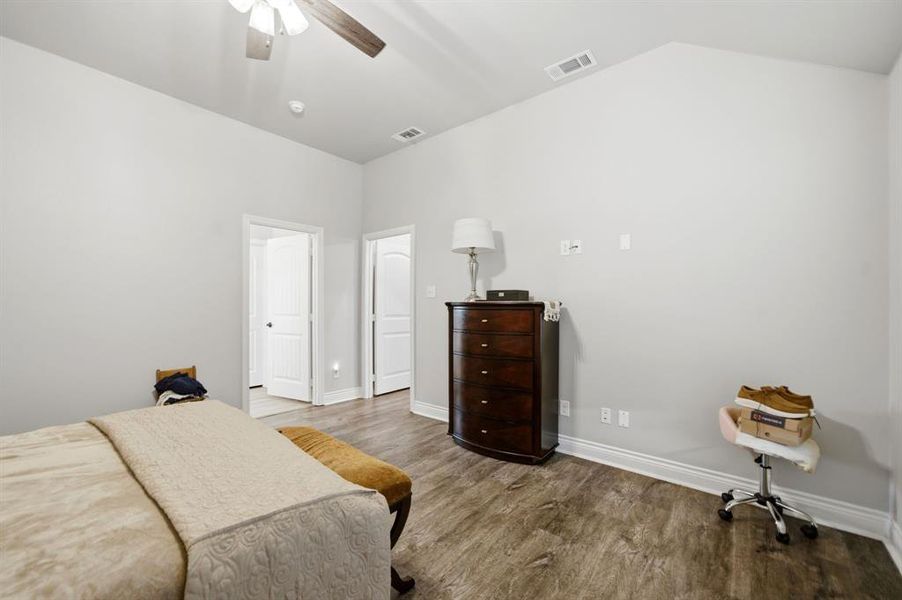 Bedroom featuring dark wood-style floors, a ceiling fan, and vaulted ceiling