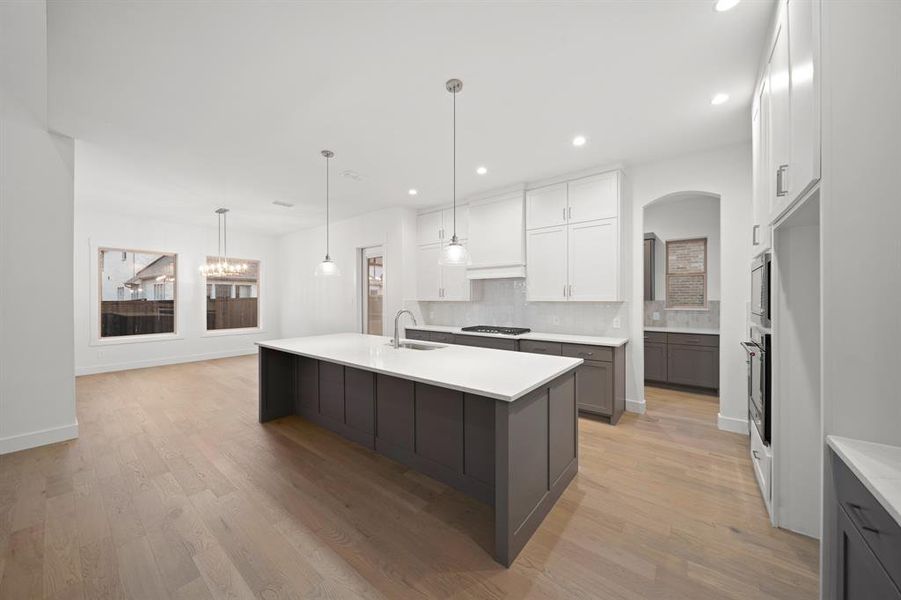 Kitchen with white cabinetry, gray cabinets, backsplash, pendant lighting, and recessed lighting