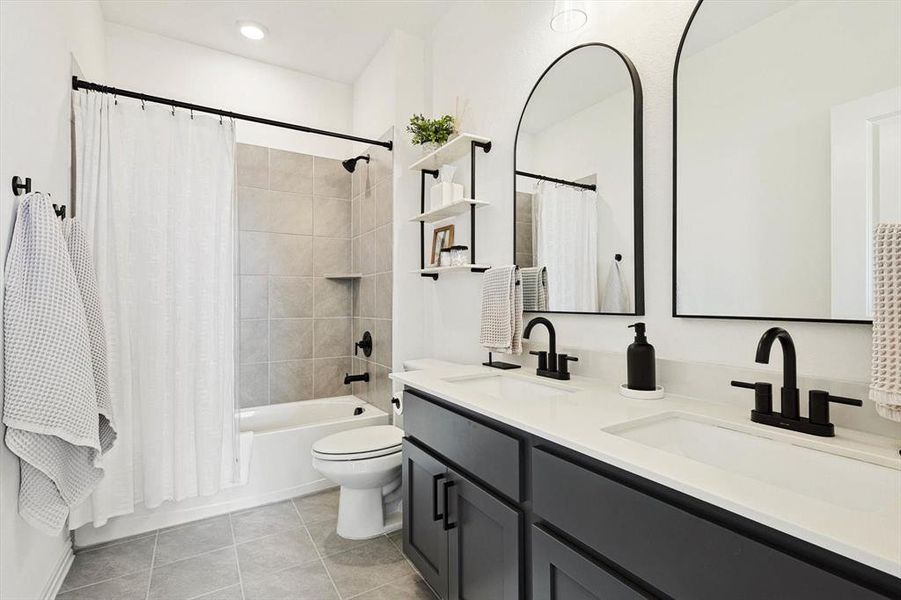 Full bathroom with tile patterned flooring, toilet, dual bowl vanity, and shower / bath combination with curtain