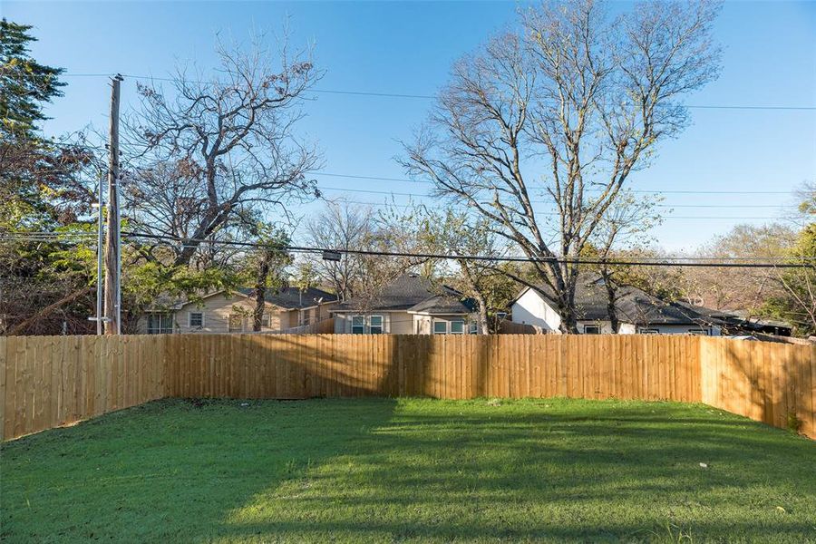 Fenced backyard with a residential view Fenced backyard with a residential view