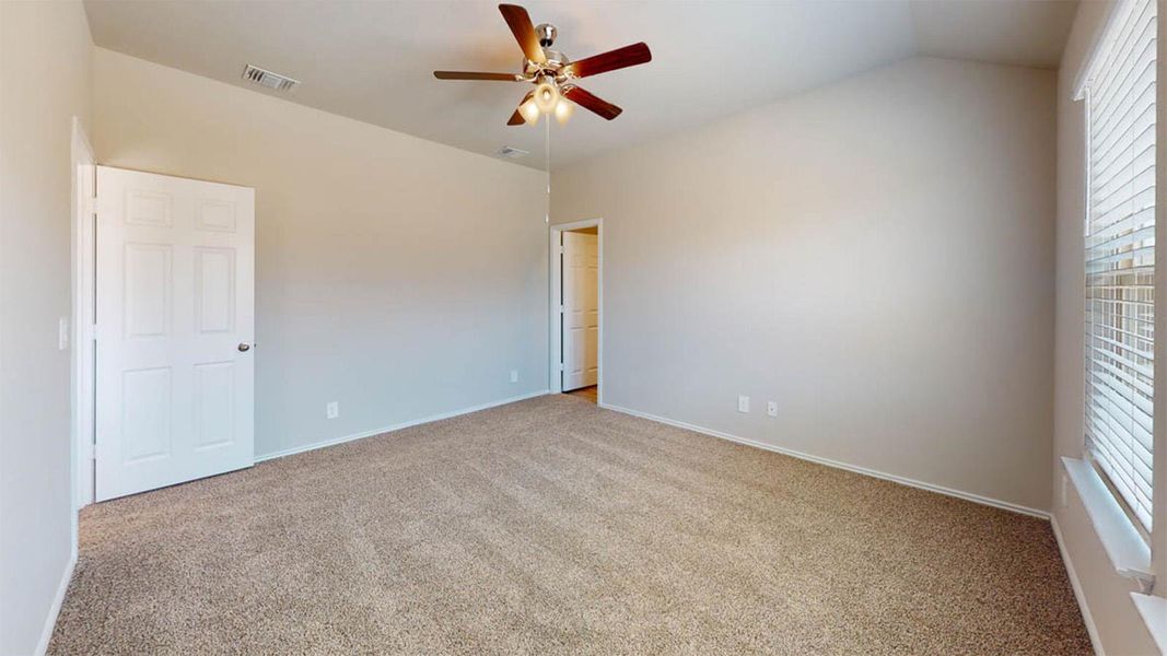 Carpeted empty room featuring ceiling fan and vaulted ceiling Carpeted empty room featuring ceiling fan and vaulted ceiling
