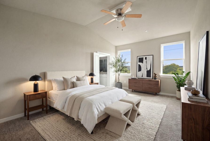 High vaulted ceilings and soft carpet floor create a serene primary bedroom atmosphere.