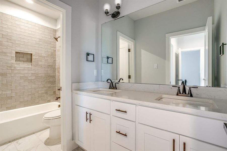 Full bath featuring double vanity and shower / bathtub combination