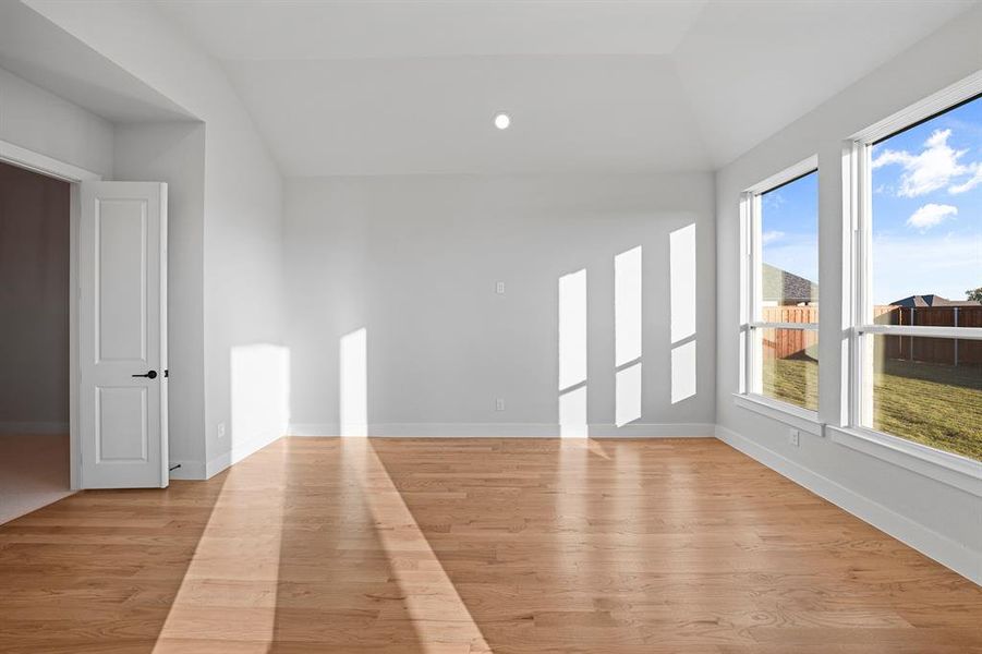 Spare room with recessed lighting, light wood-type flooring, and lofted ceiling Spare room with recessed lighting, light wood-type flooring, and lofted ceiling