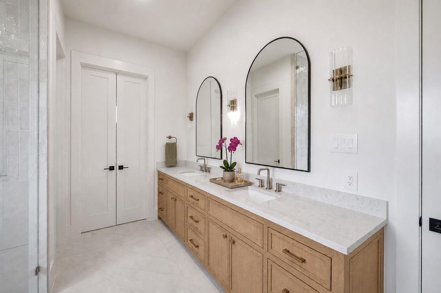 Vanity offers dual sinks, quartz countertops and custom cabinetry.