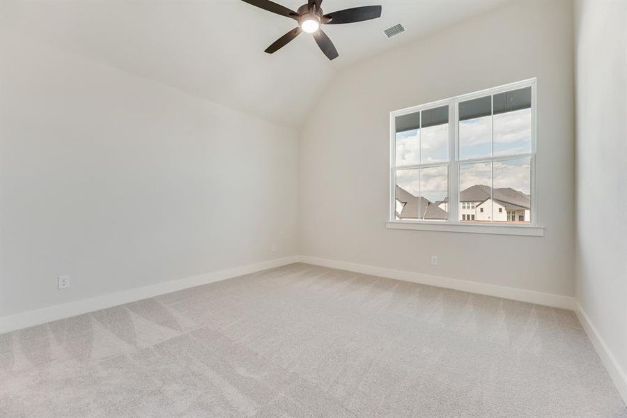 Unfurnished room with light colored carpet, vaulted ceiling, and a ceiling fan Unfurnished room with light colored carpet, vaulted ceiling, and a ceiling fan