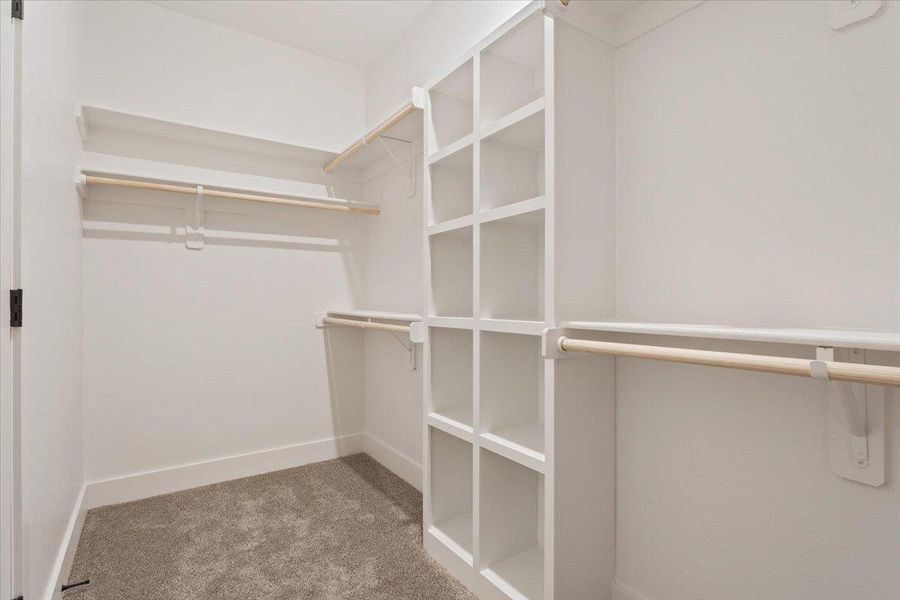 Ample built-in shelving and hanging rods provide versatile storage in this well-organized closet.