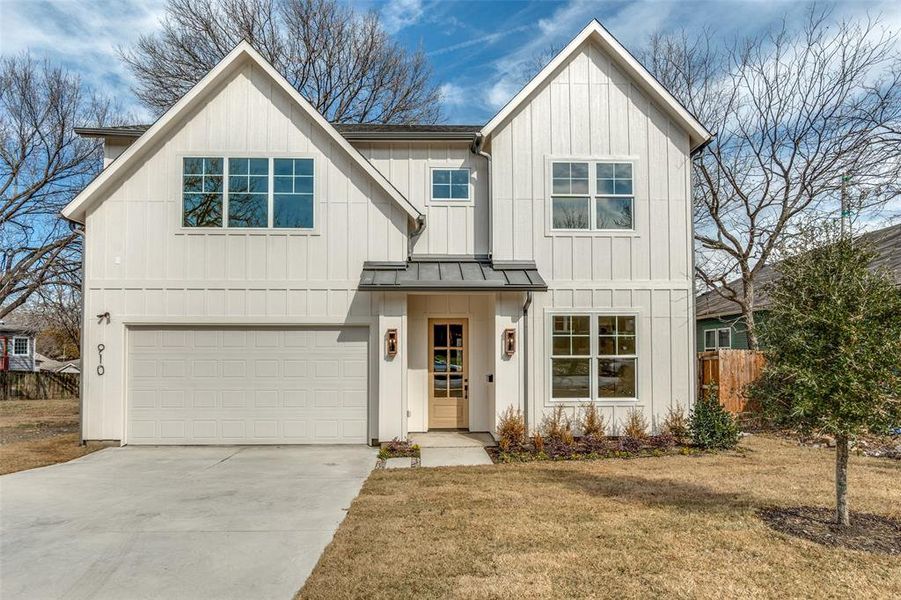 Modern inspired farmhouse with a garage and a front lawn