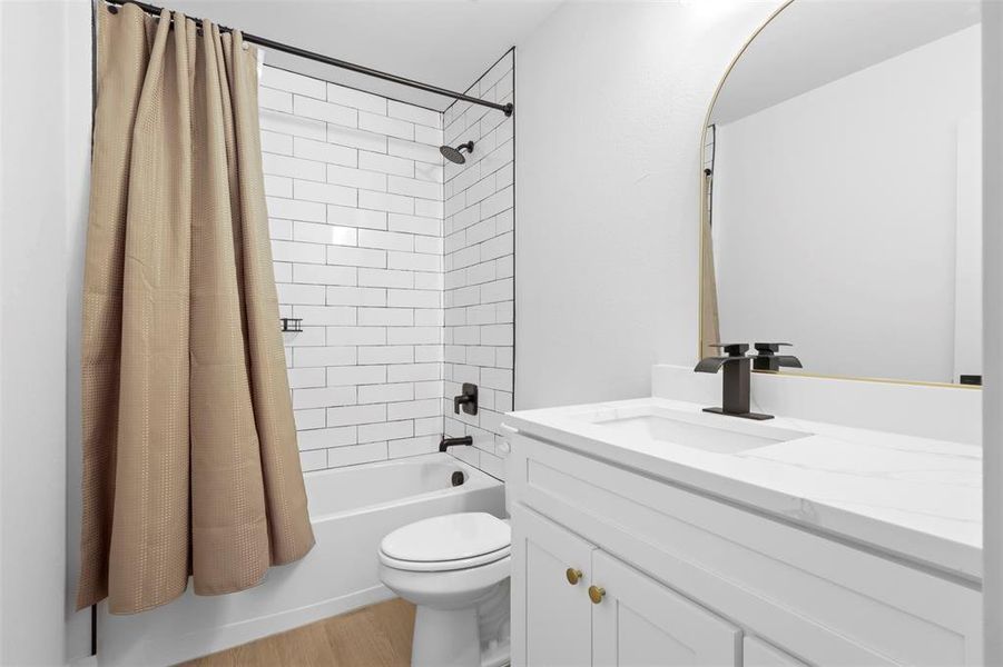 Full bathroom featuring toilet, shower / bathtub combination with curtain, wood-type flooring, and vanity