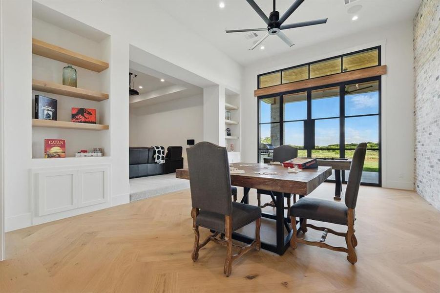 Dining room with built in features, recessed lighting, ceiling fan, and a towering ceiling Dining room with built in features, recessed lighting, ceiling fan, and a towering ceiling
