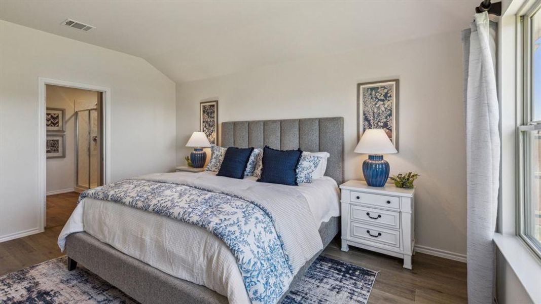 Bedroom with lofted ceiling, dark wood-type flooring, and ensuite bathroom