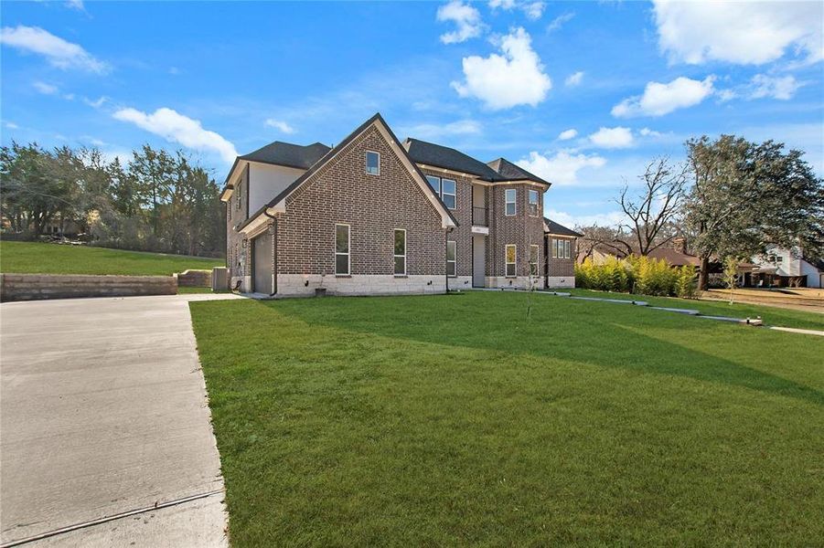View of front of property with a front yard, brick siding, driveway, and a garage View of front of property with a front yard, brick siding, driveway, and a garage