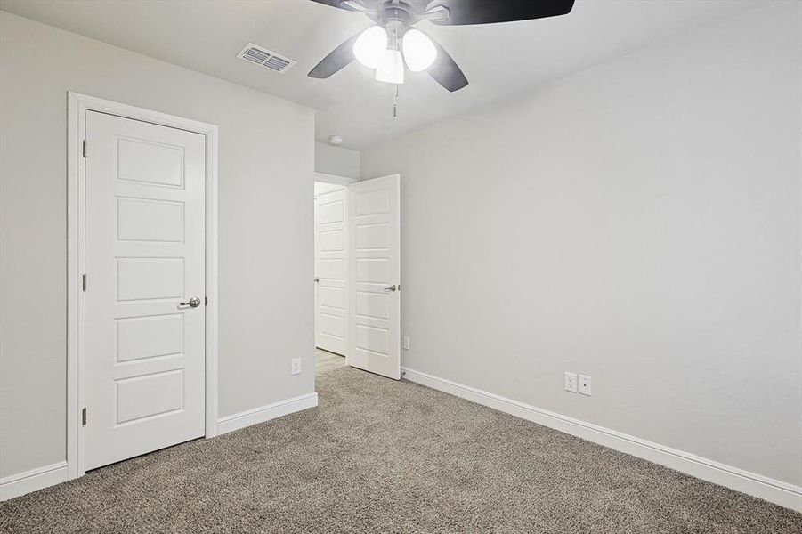 Unfurnished bedroom with a ceiling fan, baseboards, visible vents, and carpet flooring