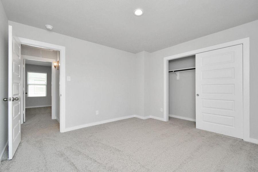 Generously sized secondary bedrooms featuring spacious closets, soft and inviting carpeting underfoot, large windows allowing plenty of natural light, and the added touch of privacy blinds for your personal retreat. Sample photo of completed home with similar floor plan. Actual colors and selections may vary.