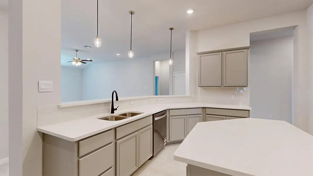 Kitchen with gray cabinets, pendant lighting, ceiling fan, stainless steel dishwasher, and light stone countertops Kitchen with gray cabinets, pendant lighting, ceiling fan, stainless steel dishwasher, and light stone countertops