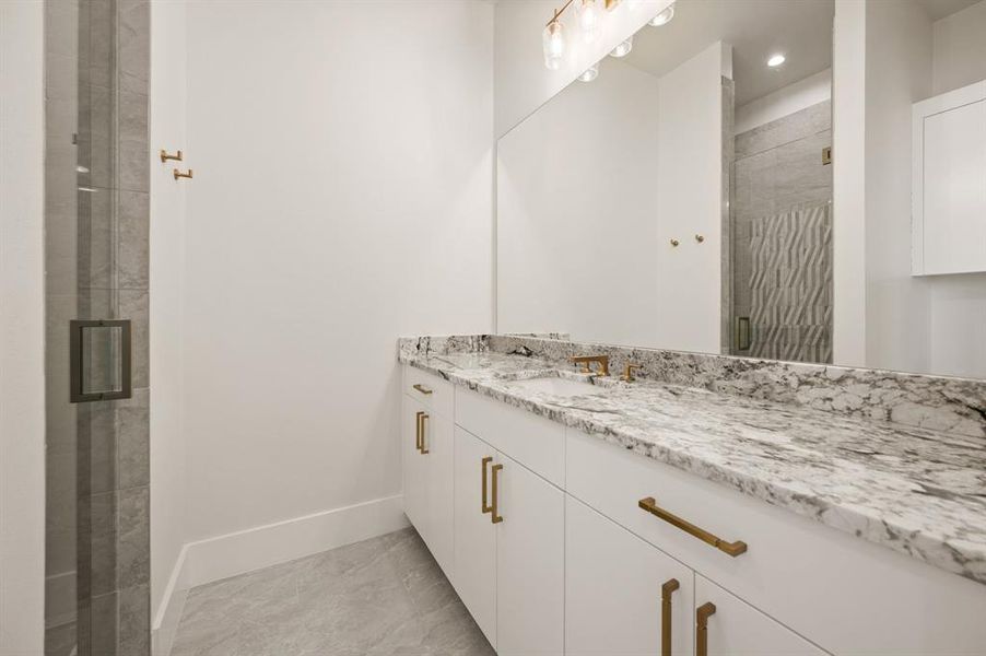 Bathroom featuring vanity and a shower with door