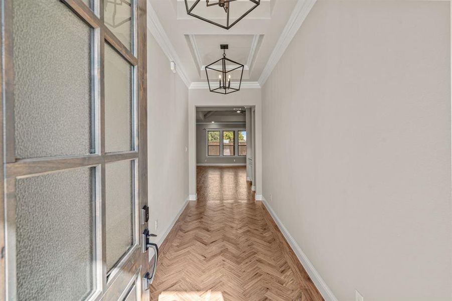 Corridor with crown molding and a chandelier Corridor with crown molding and a chandelier