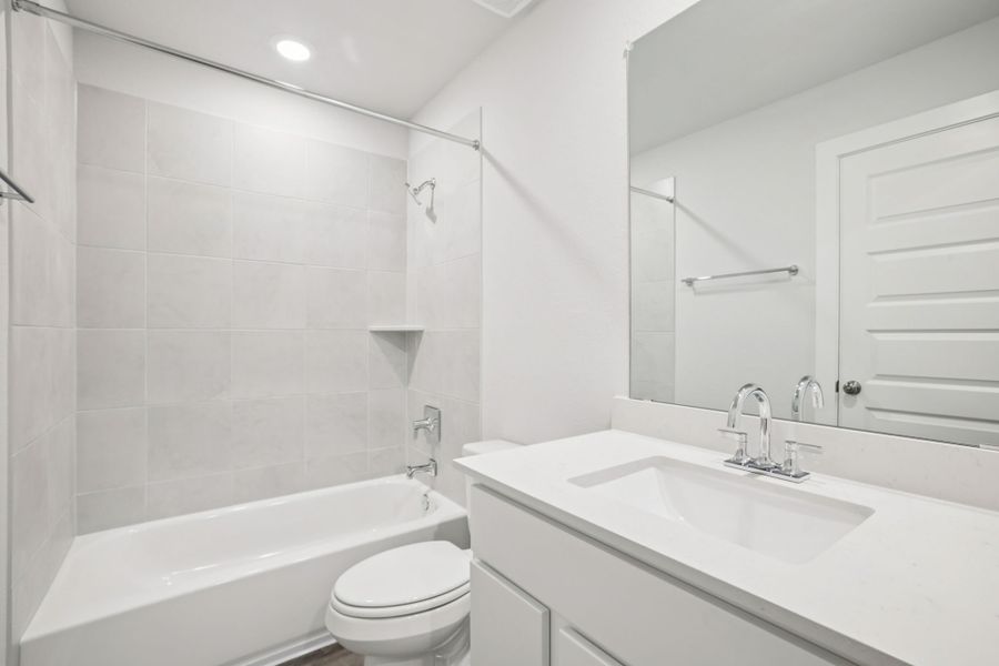 A bathroom with a tub sink and toilet.