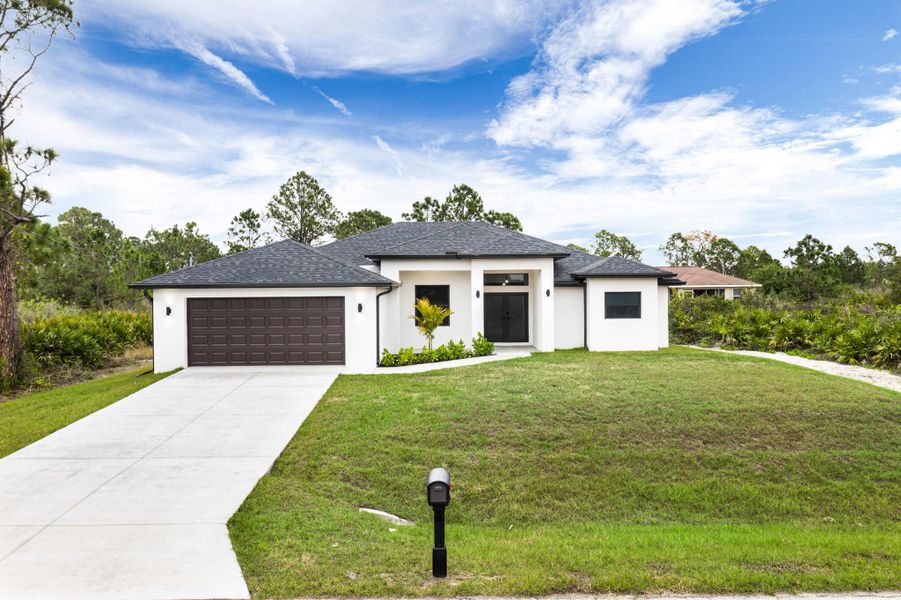 Front exterior of a new home in , Lehigh Acres, FL, highlighting curb appeal (Image 1).