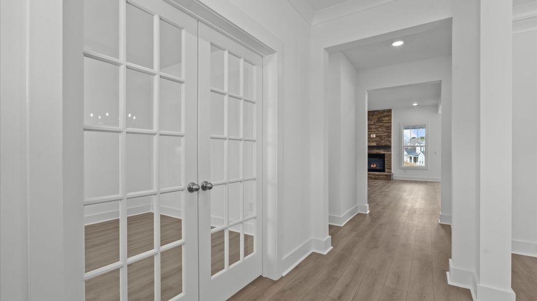 Exceptional home office with glass-paneled French doors and refined finishes throughout