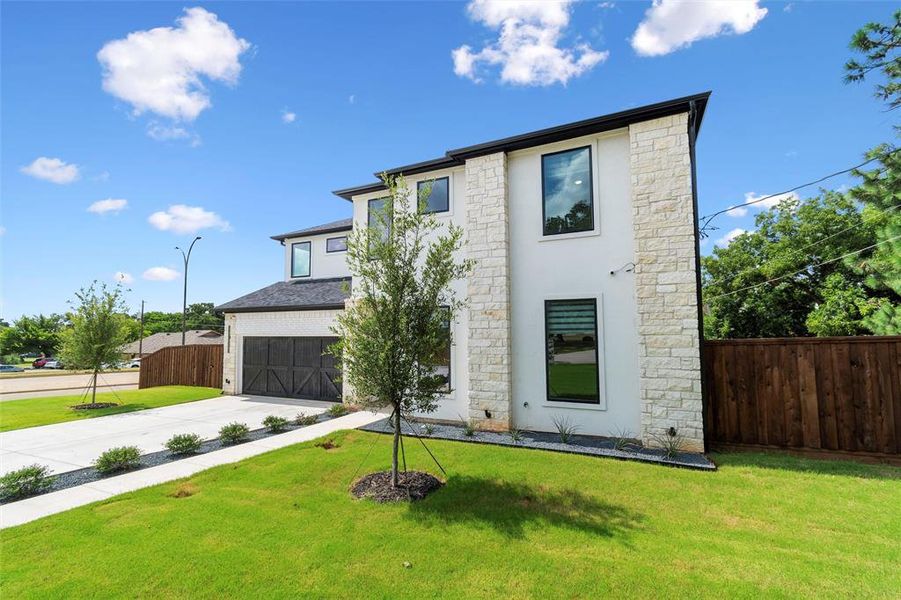 Contemporary exterior featuring white stucco and stone veneer accents